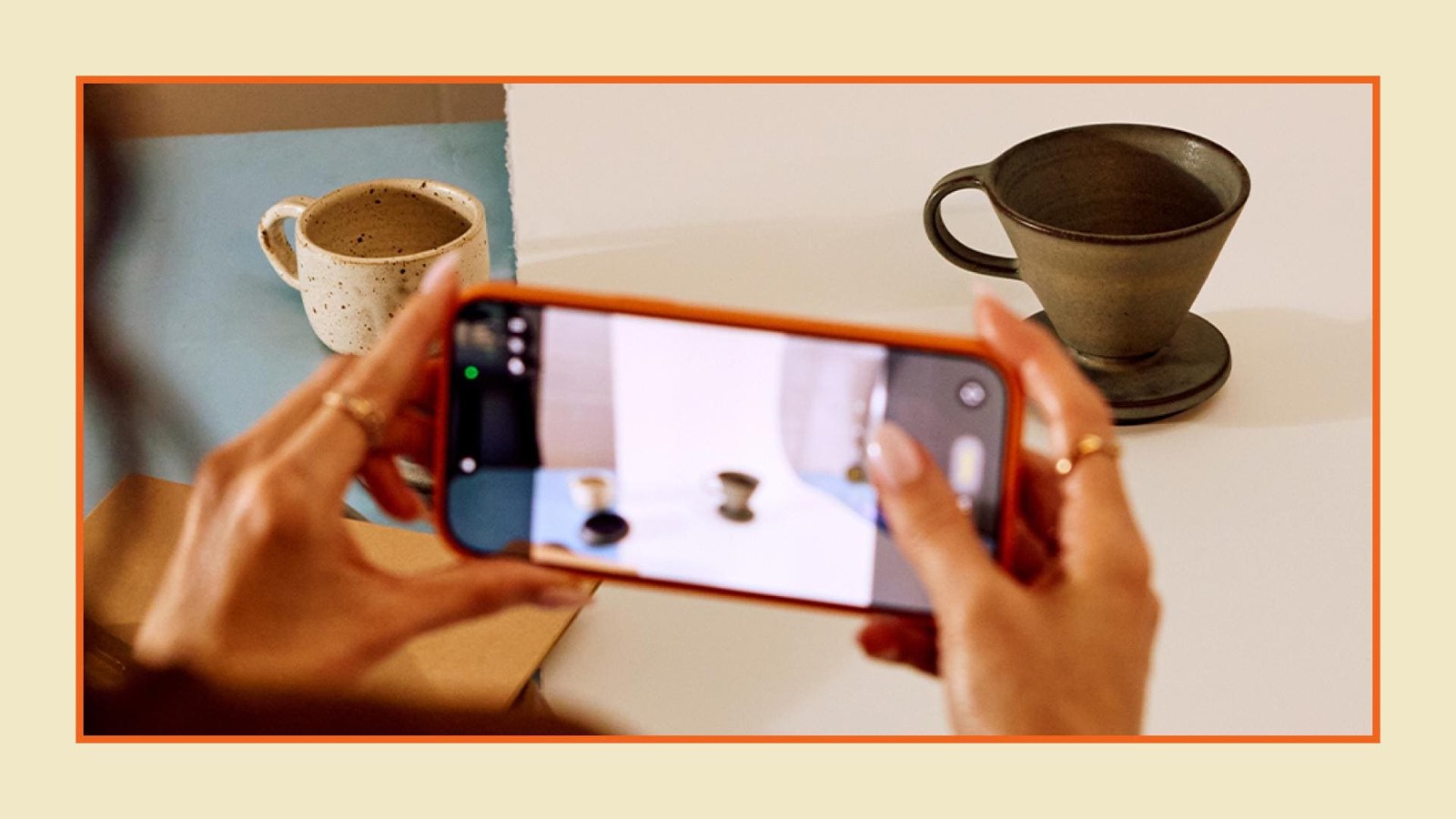 A seller photographs a ceramic mug with her phone on a table, with no added backdrop